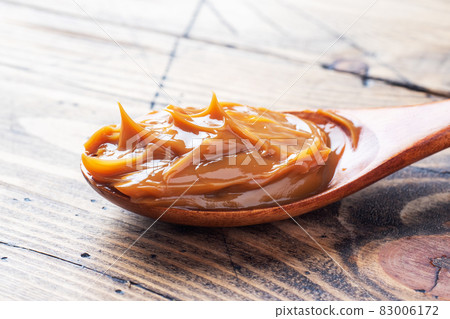 Boiled condensed milk in a spoon. Sweet pasta spread for Breakfast and dessert. Copy space. 83006172
