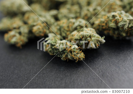 Marijuana cbd buds close-up. Medicinal cannabis blooms on black background. Marijuana cbd buds close-up. Medicinal cannabis blooms on black background. 83007210