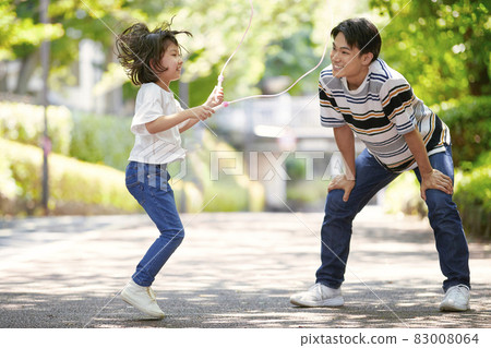 Girl and dad jumping rope Girl and dad jumping rope 83008064