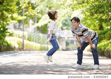 Girl and dad jumping rope 83008065