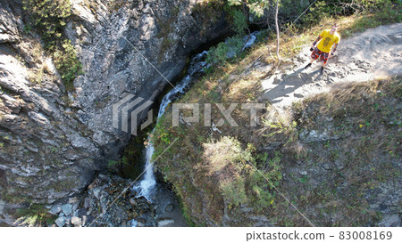 The guy is standing on the edge of the cliff 83008169