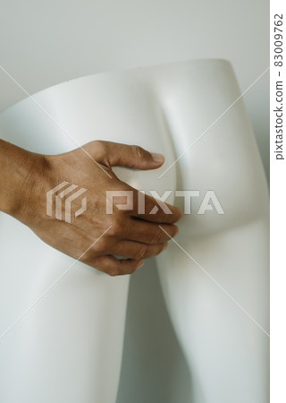 man is touching the buttocks of a mannequin 83009762
