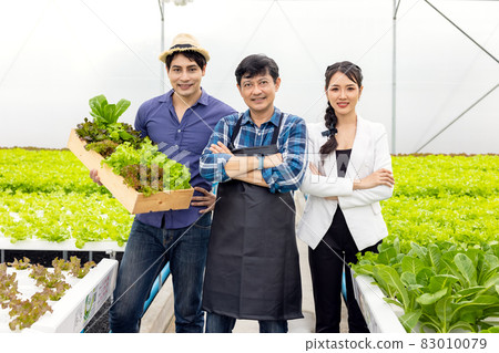 A guy and a woman farmer present on the farm with a smile and pride in their own start-up business in a hydroponic vegetable greenhouse with happiness and joy in the backdrop. A guy and a woman farmer present on the farm with a smile and pride in their own start-up business in a hydroponic vegetable greenhouse with happiness and joy in the backdrop. 83010079