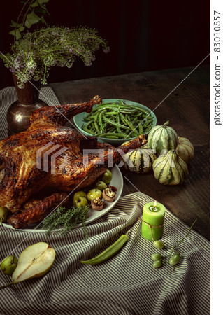 Top view of holiday decorated table with roasted turkey and season traditional vegetables. Thanksgiving day, national traditions Top view of holiday decorated table with roasted turkey and season traditional vegetables. Thanksgiving day, national traditions 83010857