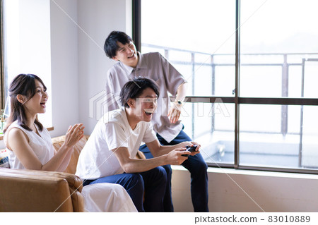 Young men and women playing video games at home 83010889