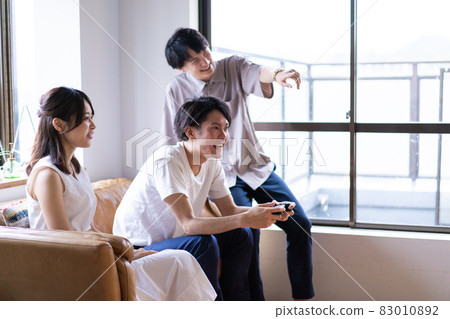 Young men and women playing video games at home 83010892