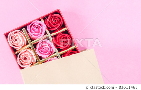 Many colored Artificial rose in box on pink background. Many colored Artificial rose in box on pink background. 83011463