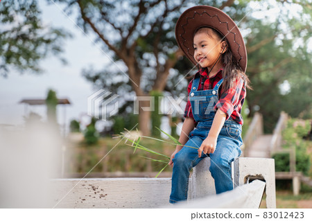 A farmer girl is happily raising animals. 83012423