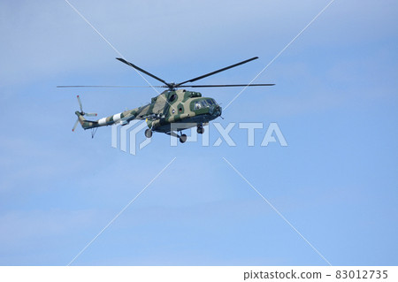 Military battle helicopter flying in a blue sky Military battle helicopter flying in a blue sky 83012735