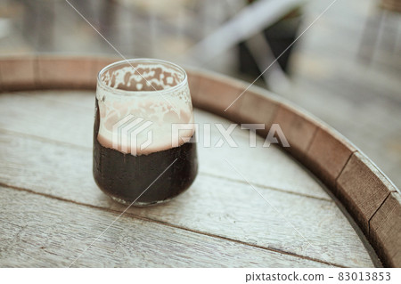 Dark cold beer on wooden barrel with copyspace, selective focus in a street cafe 83013853