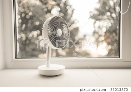 Modern electric portable fan in bedroom. Cooling of high air temperature. Minimal style, copy space. 83013870