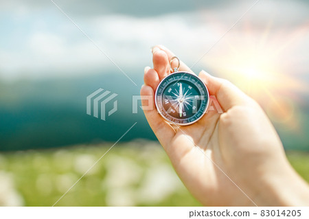 Traveler hand holds a compass on the beautiful Carpathian mountains view. Horizontal banner with place for text. Vacation and travel. 83014205