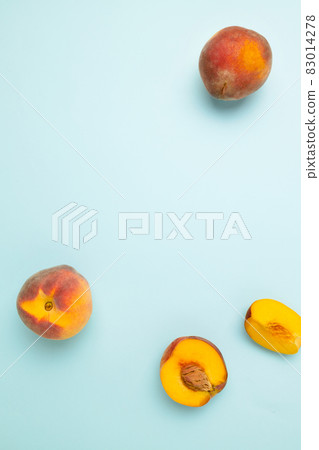 Fresh juicy peaches with leaves on a blue background. Top view fresh organic fruit food with copy space. Frame made of fresh peashes. 83014278