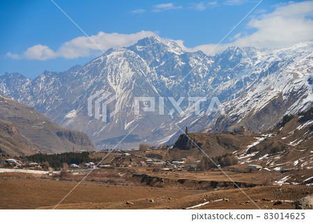 In a mountain valley, a breathtaking landscape of giant covered mountains in the background In a mountain valley, a breathtaking landscape of giant covered mountains in the background 83014625