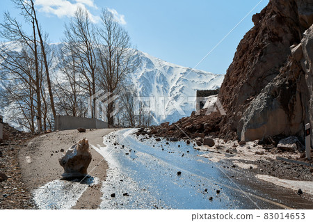 Early spring in the mountains. The rocks fell on the road. Dangerous bugle road. Rockfall in the mountains Early spring in the mountains. The rocks fell on the road. Dangerous bugle road. Rockfall in the mountains 83014653