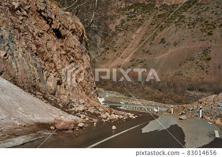 Early spring in the mountains. The rocks fell on the road. Dangerous bugle road. Rockfall in the mountains Early spring in the mountains. The rocks fell on the road. Dangerous bugle road. Rockfall in the mountains 83014656