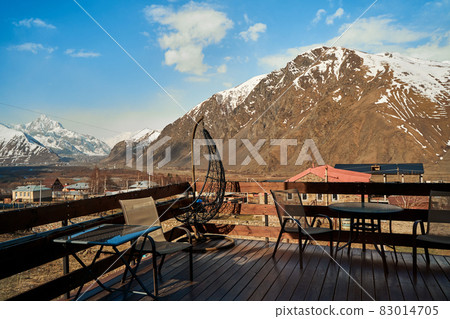 Terrace of a house in a village in the mountains. Breathtaking views of the snow-capped mountains Terrace of a house in a village in the mountains. Breathtaking views of the snow-capped mountains 83014705