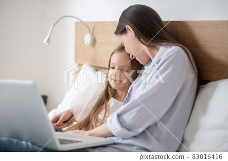 Mom and daughter spending time together and looking peaceful Mom and daughter spending time together and looking peaceful 83016416