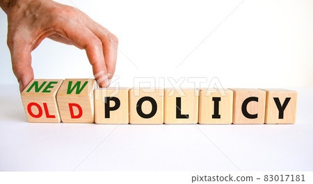 New or old policy symbol. Businessman turns wooden cubes and changes words 'old policy' to 'new policy'. Beautiful white table, white background. Business, old or new policy concept. Copy space. 83017181