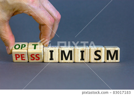 Male hand turns cubes and changes the expression 'pessimism' to 'optimism'. Beautiful grey background. Business concept. Copy space. 83017183