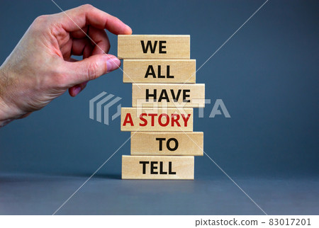 We all have a story to tell symbol. Wooden blocks with words 'We all have a story to tell'. Businessman hand. Beautiful grey background. Business, popular quotation concept. Copy space. 83017201