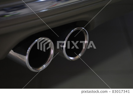 Twin chrome tailpipe of powerful sports car with black body and gray plastic parts 83017341