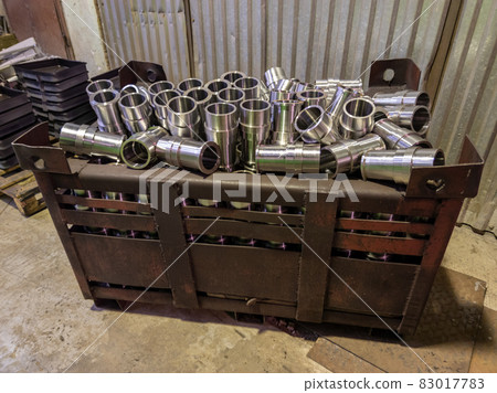 shiny steel parts overflowing big intermodal steel container box on factory floor 83017783