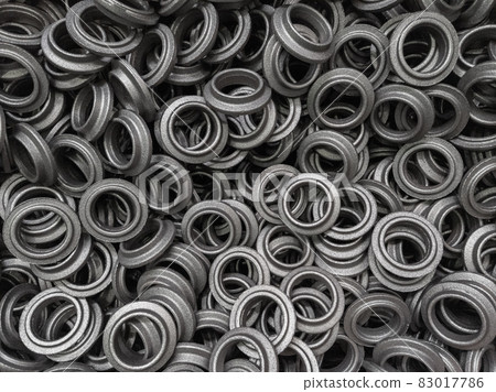 heap of grey steel ring forgings after shot blasting - close-up natural heavy industrial pattern with selective focus 83017786