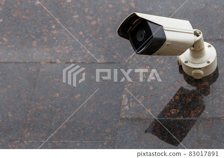 small cheap surveillance camera on tan brown granite wall small cheap surveillance camera on tan brown granite wall 83017891