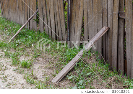 old dusty rickety wooden fence with plank props and grass close up with selective focus old dusty rickety wooden fence with plank props and grass close up with selective focus 83018291