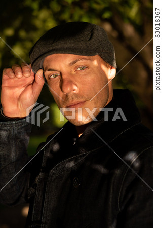 Adult handsome man in a coat and cap. Adult handsome man in a coat and cap. 83018367