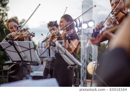 Violin players giving concert on the street 83018384