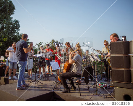 Musical ensemble playing classic instrumental music outdoors 83018396