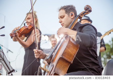 Musicians playing classical instrumental music on the street Musicians playing classical instrumental music on the street 83018403