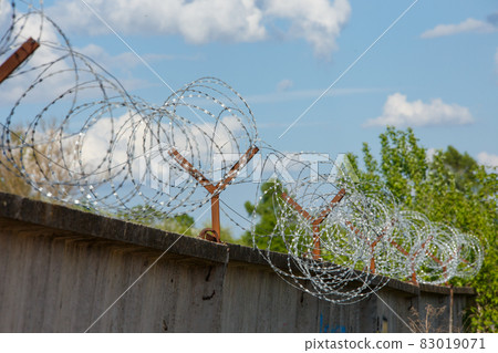 close-up view of barb wire over concrete fence 83019071