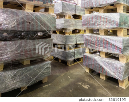 abstract industrial palleted production stacks indoors on the floor 83019195