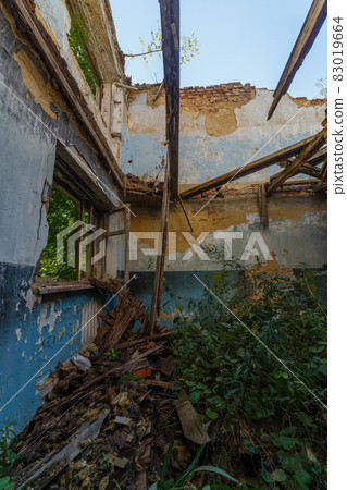 broken wooden window and room with tall grass, view inside of an abandoned half-destroyed dormitory at summer daylight broken wooden window and room with tall grass, view inside of an abandoned half-destroyed dormitory at summer daylight 83019664