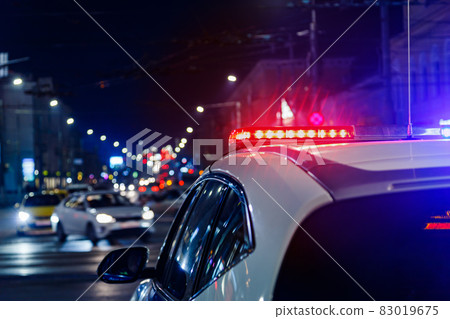 police car lights in night city with selective focus and bokeh 83019675