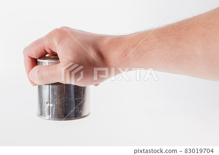 bare caucasian hand holding a tin can with a pull ring on a white background 83019704