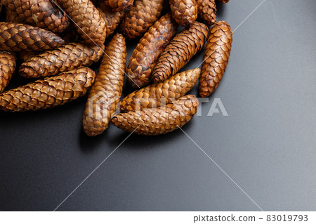 pile of fir cones on black plastic background 83019793
