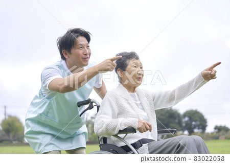 Elder caregiver and elderly person in a wheelchair Elder caregiver and elderly person in a wheelchair 83022058