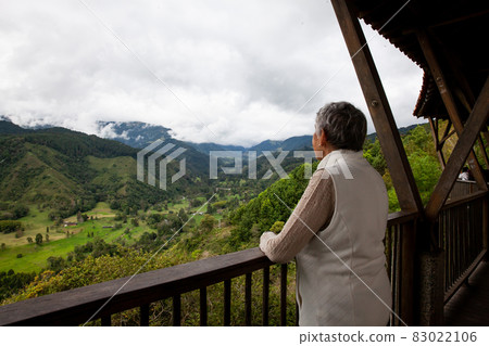Senior woman at the beautiful view point over the Cocora Valley in Salento, located on the region of Quindio in Colombia 83022106