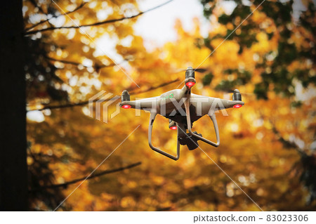 Flying drone in autumn yellow forest environment Flying drone in autumn yellow forest environment 83023306