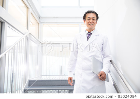 Middle-aged doctor working in a hospital Middle-aged doctor working in a hospital 83024084