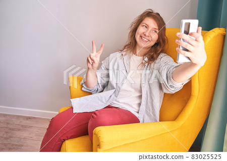 Young woman doing self portrait indoors. Home vacation portrait. Blogger selfie 83025525