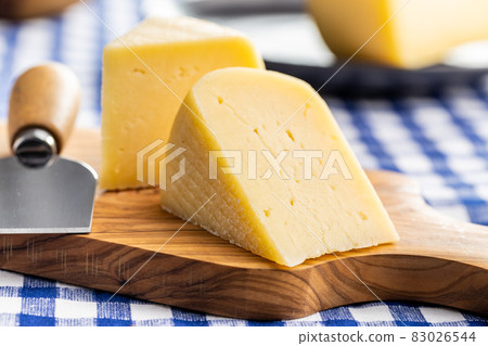 Block of hard cheese. Sliced cheese. 83026544