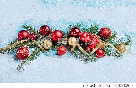 Christmas wreath red and gold Christmas balls garland fluffy fir branches blue background with snowflakes, sparkles confetti Christmas wreath red and gold Christmas balls garland fluffy fir branches blue background with snowflakes, sparkles confetti 83028269