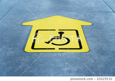 A drawing of a wheelchair on a yellow arrow glued to the tile in the waiting room A drawing of a wheelchair on a yellow arrow glued to the tile in the waiting room 83029510