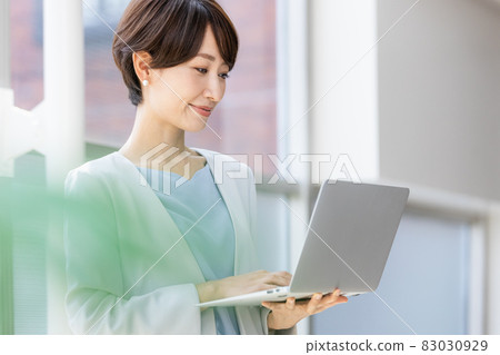 站立和研究計算機的女商人 站立和研究計算機的女商人 83030929