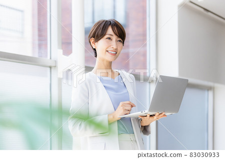 站立和研究計算機的女商人 站立和研究計算機的女商人 83030933